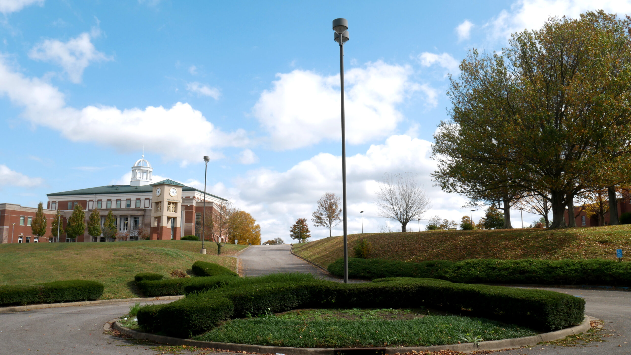 Campus entrance with clock tower building on a hill