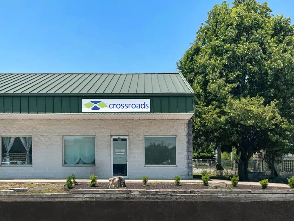 Small clinic building with Crossroads sign and trees