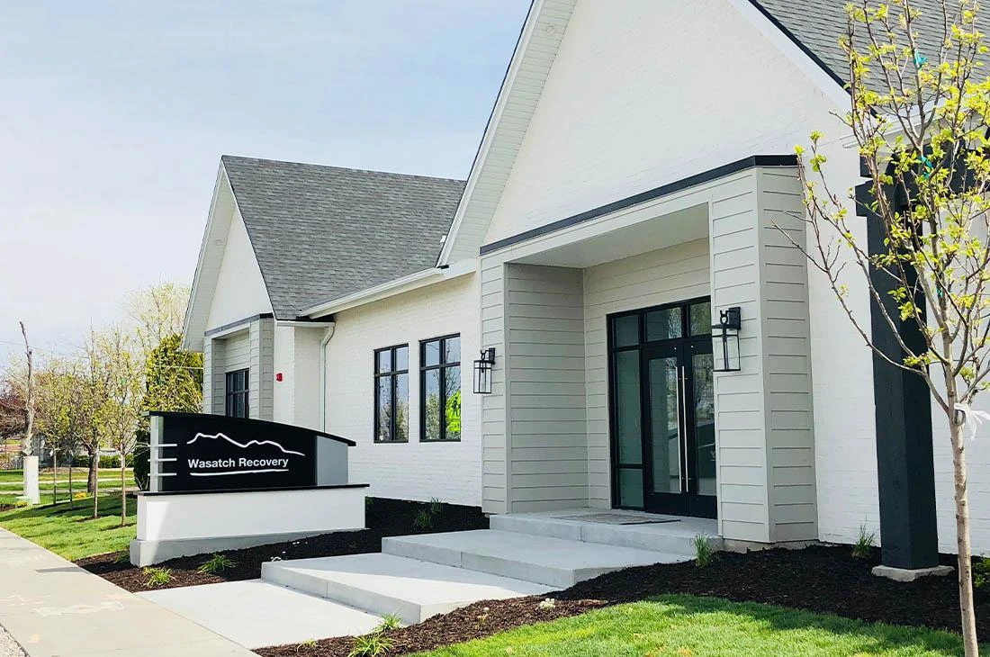 White rehab center with dark roof and Wasatch Recovery sign