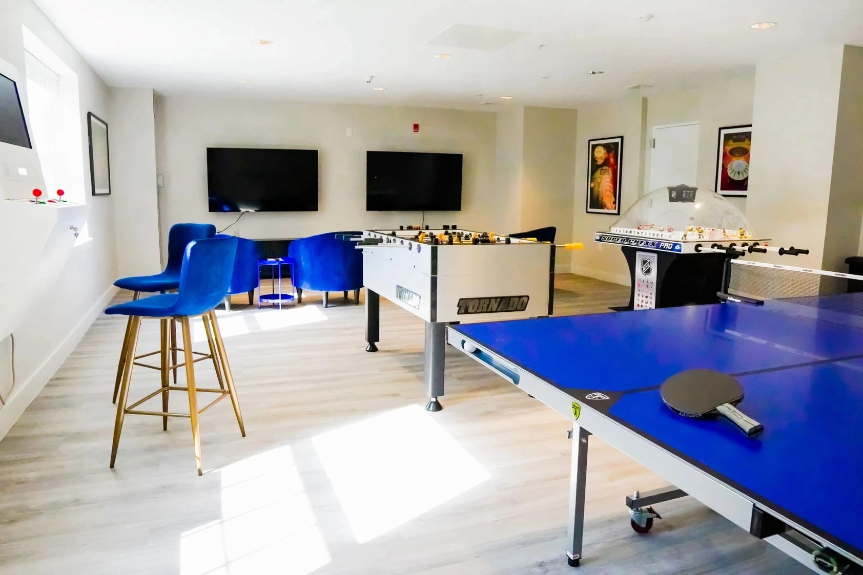 Game room with foosball, ping-pong, and seating.