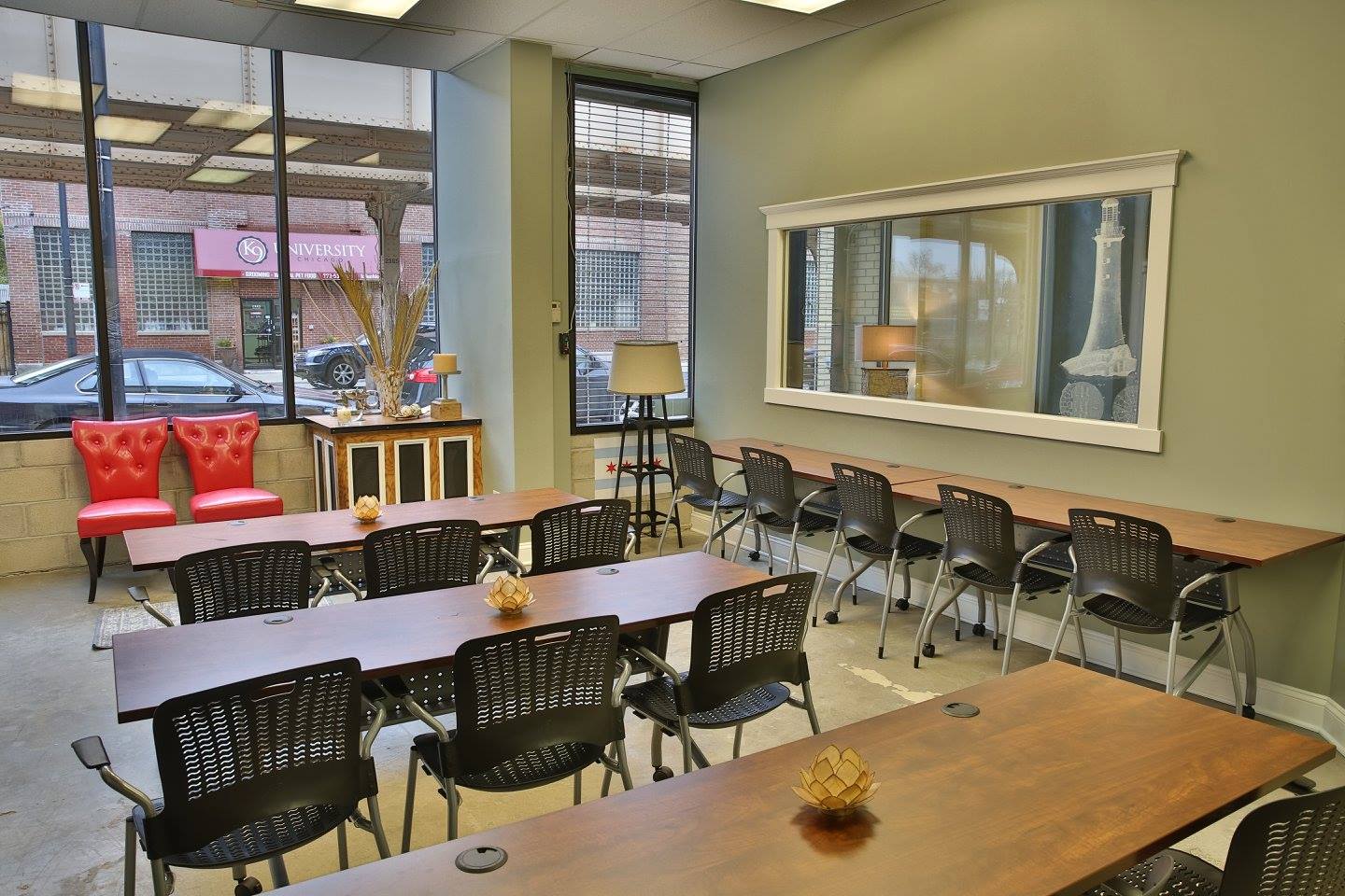 Meeting room with long tables, black chairs, and bright windows