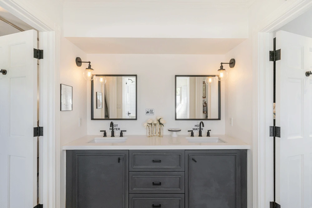 Dual-sink vanity in a shared white bathroom