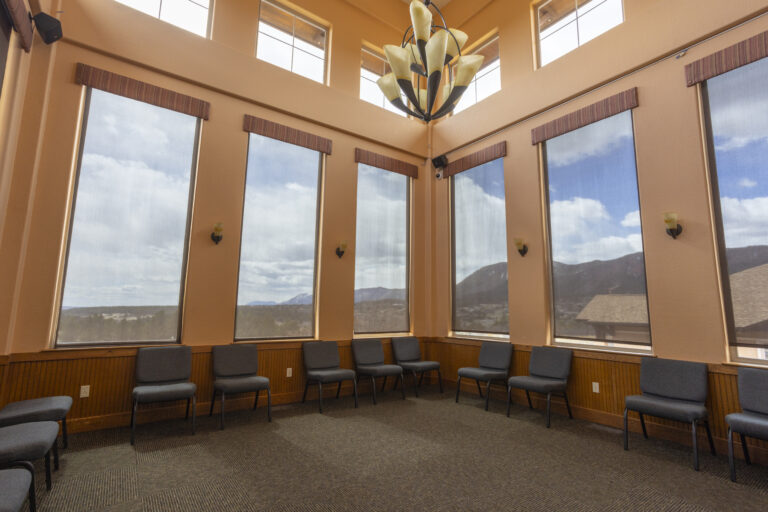 Group therapy room with chairs and tall windows