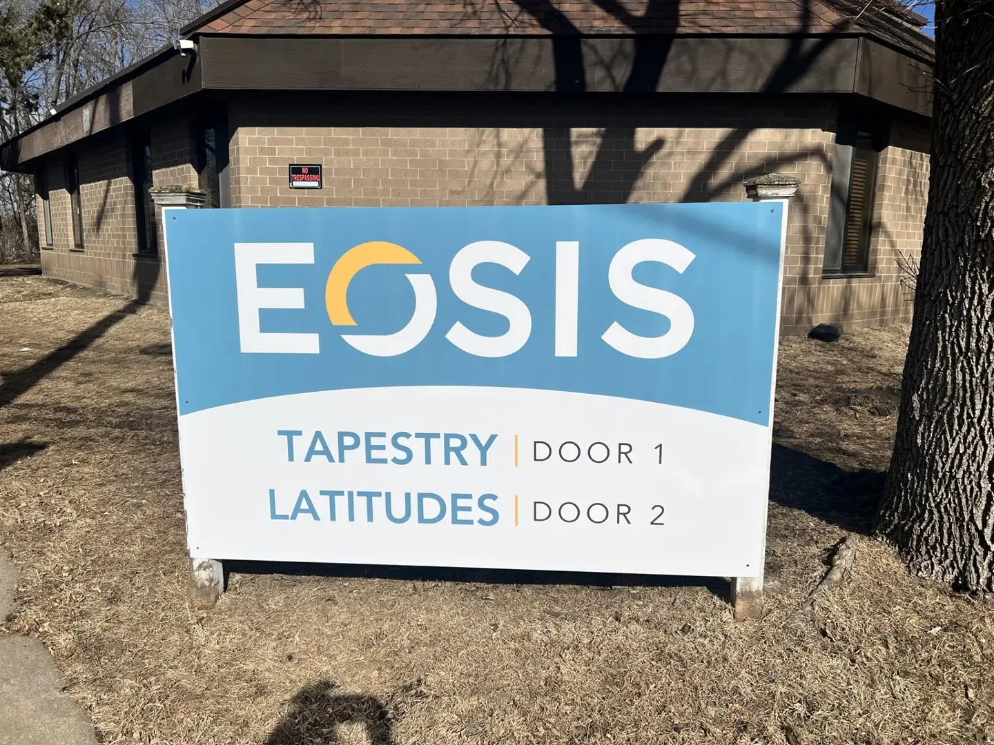 Facility sign outside reading EOSIS with program names listed