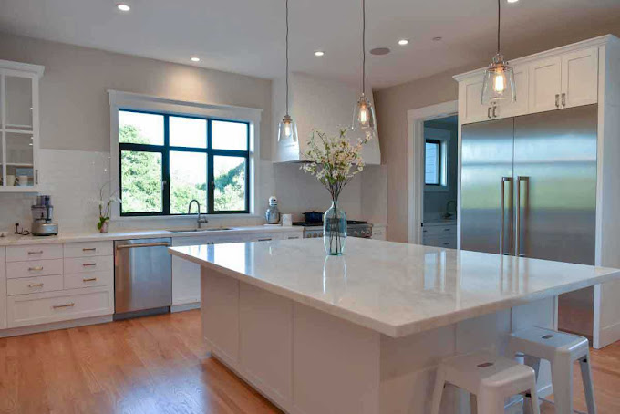 White kitchen with large island and pendant lighting
