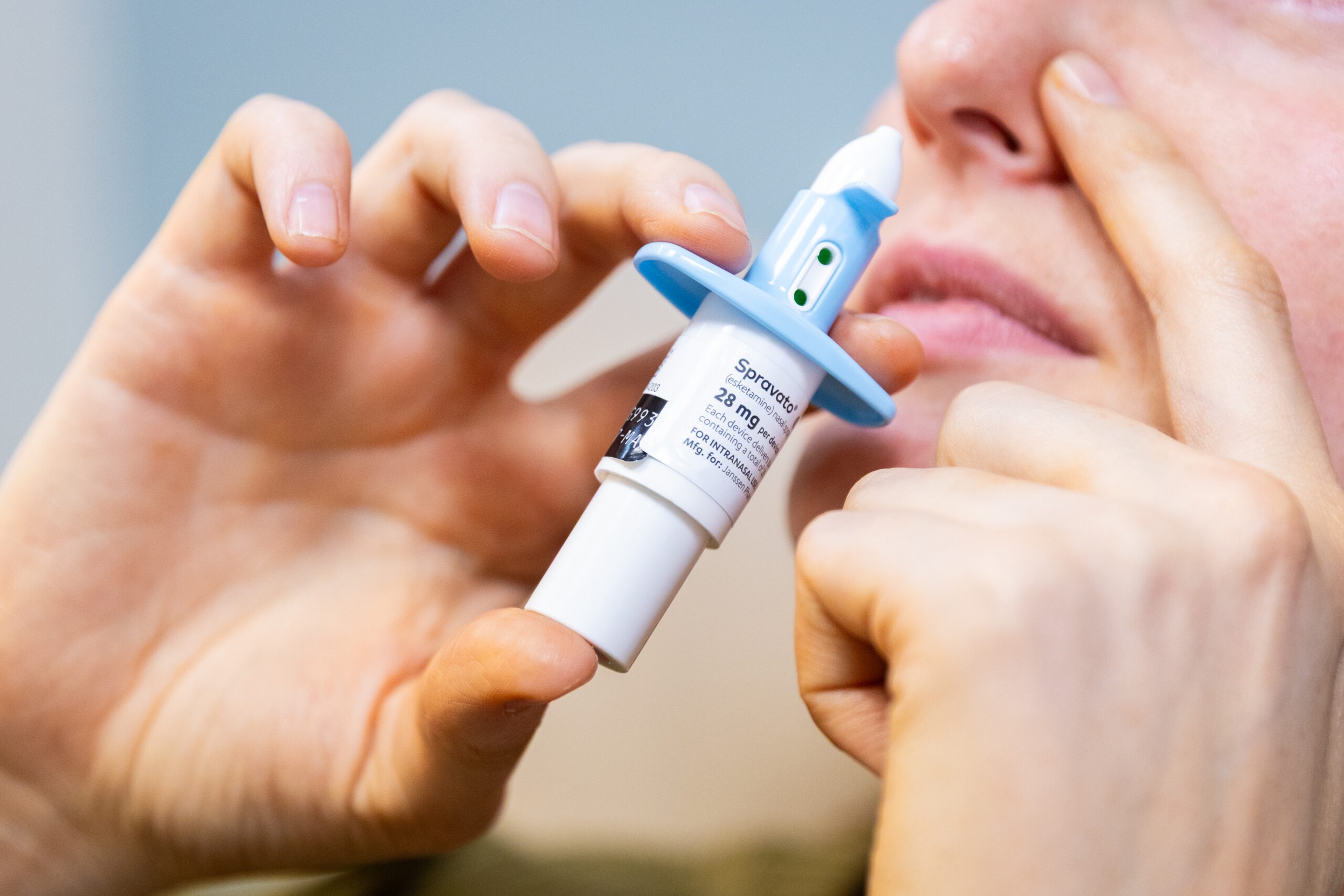 Person using a Spravato nasal spray device.