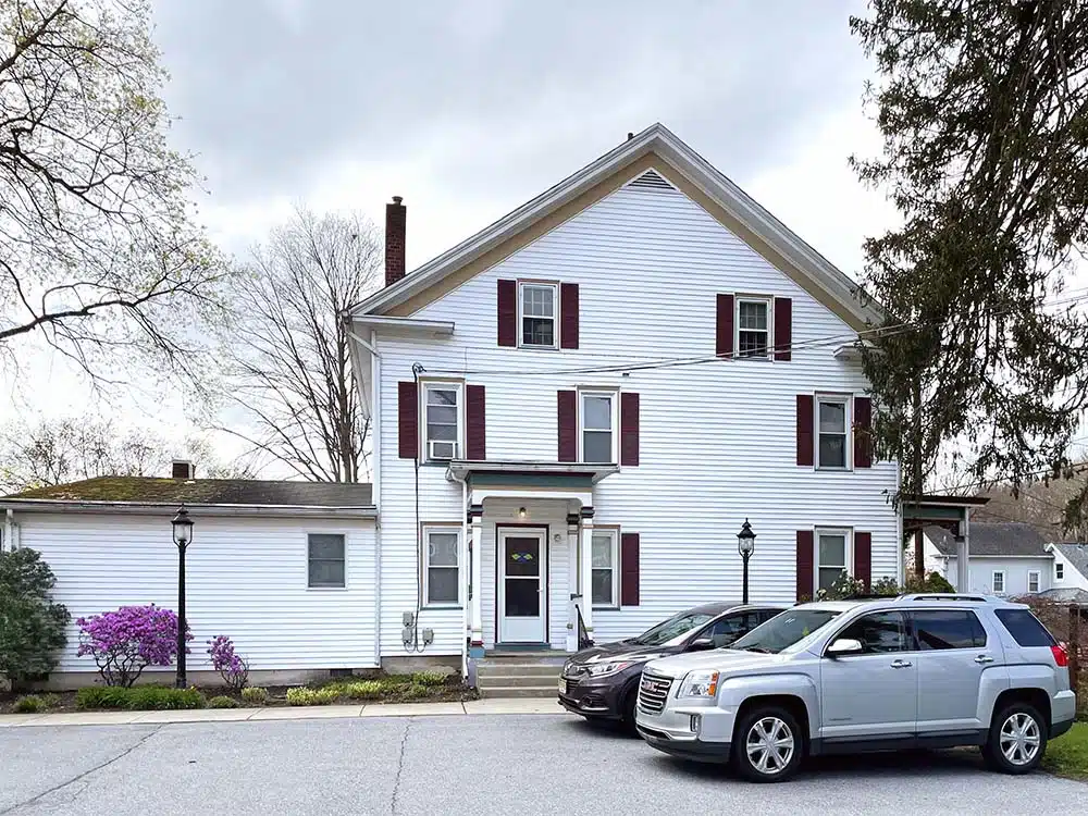 White rehab facility building with parking area and front entrance