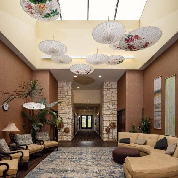 Cozy indoor sitting area with lounge chairs, decorative umbrellas on ceiling, and natural stone accents