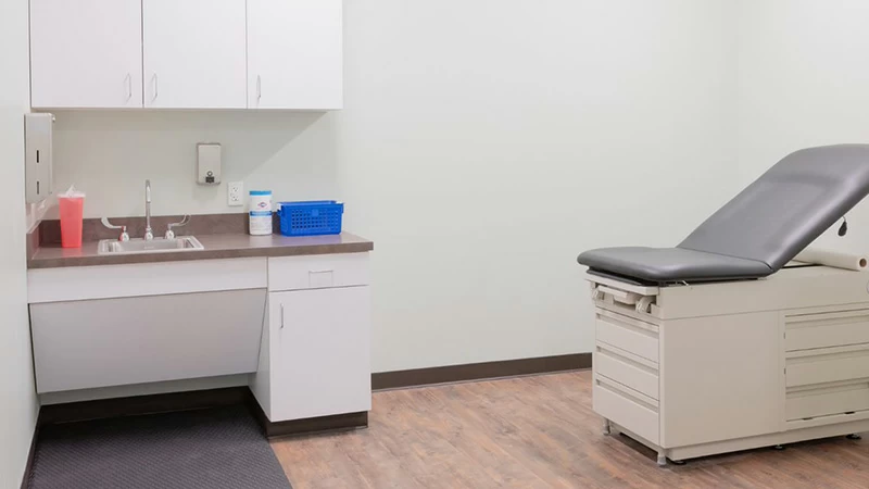 Medical exam room with treatment table and sink