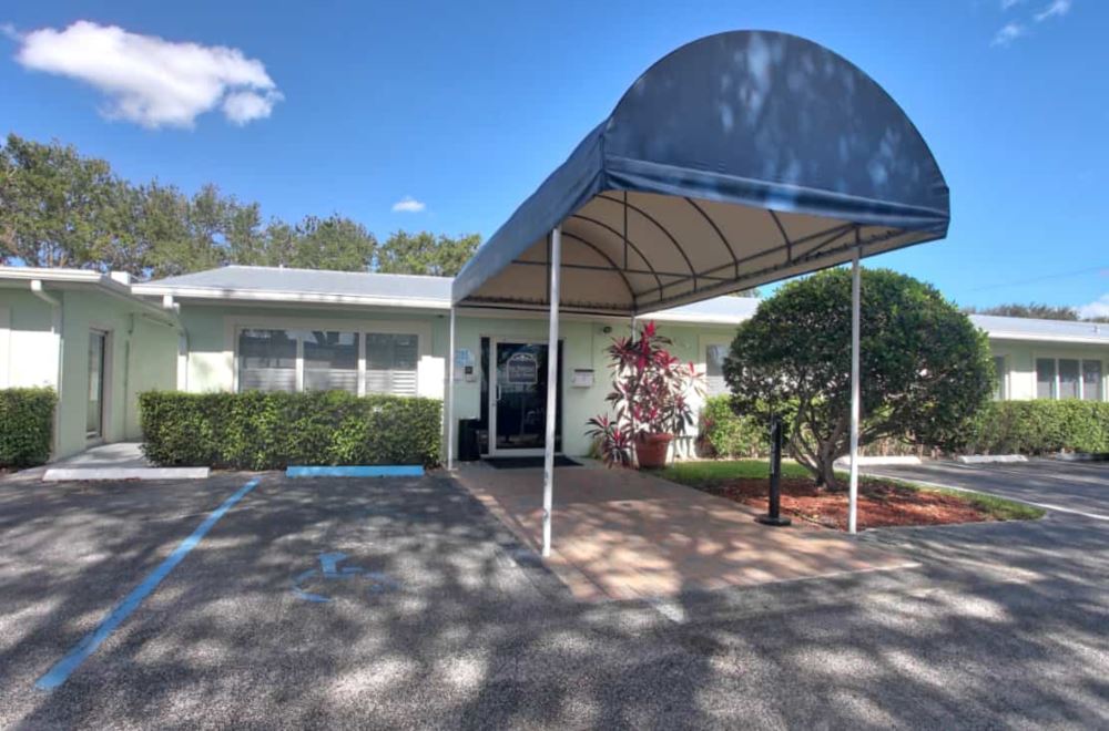 Rehab center exterior with covered walkway and blue awning