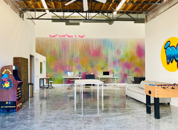 Bright and inviting lobby area with modern furniture and a colorful mural, creating a welcoming atmosphere.