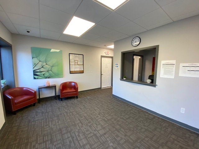 Reception area with wall art and  waiting chairs.