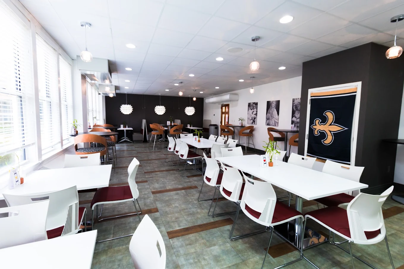 Clean, contemporary dining room with white tables, red chairs, and decorative lighting at NOLA Detox