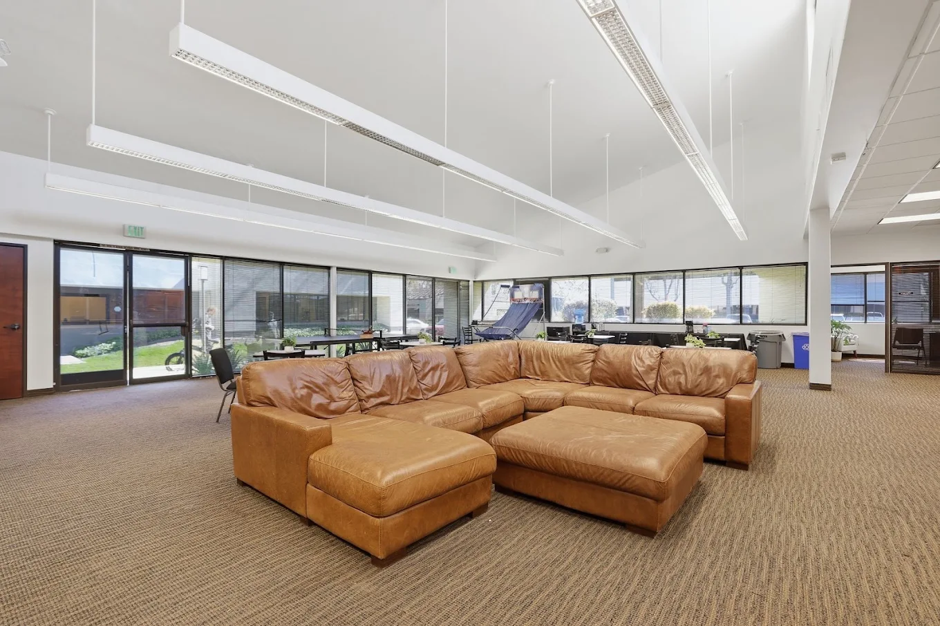 Spacious client lounge with sectional sofa and large windows