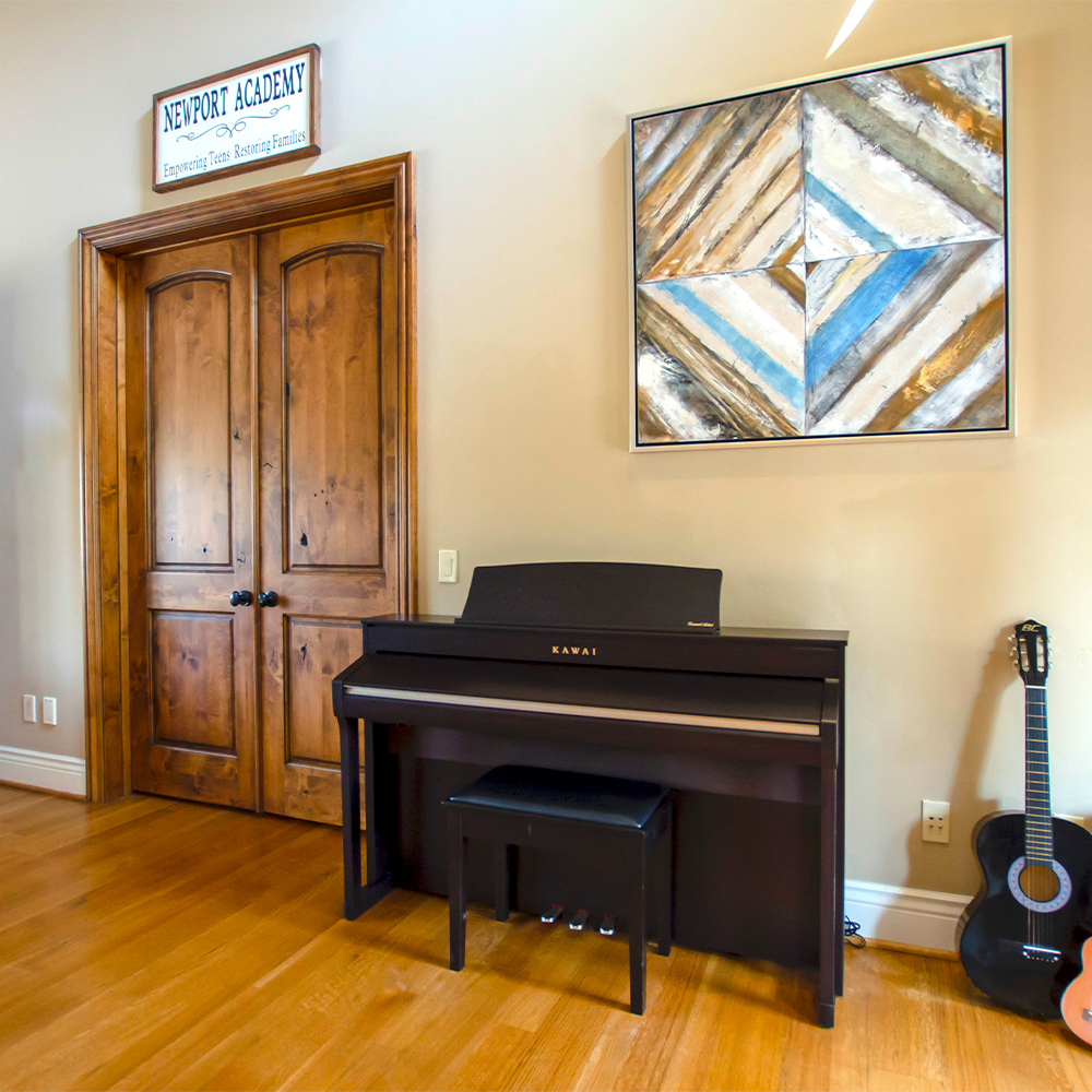 Lving room with a piano and a guitar.