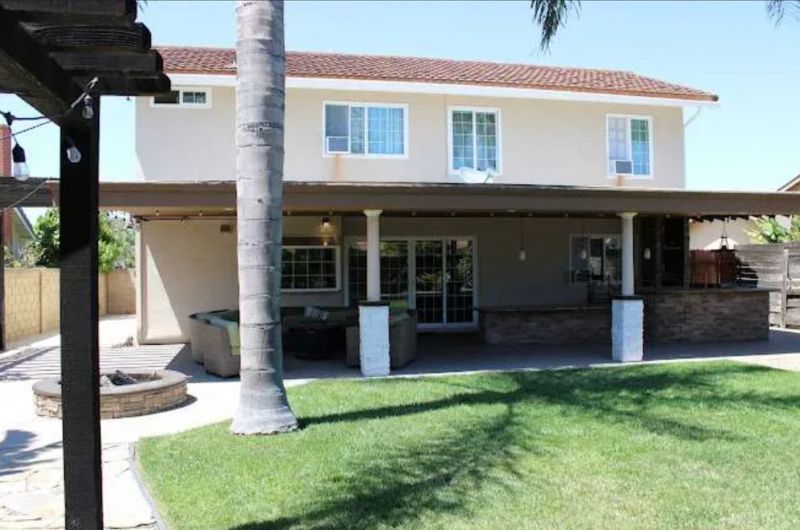 Entrance with a patio, seating, and a lawn.