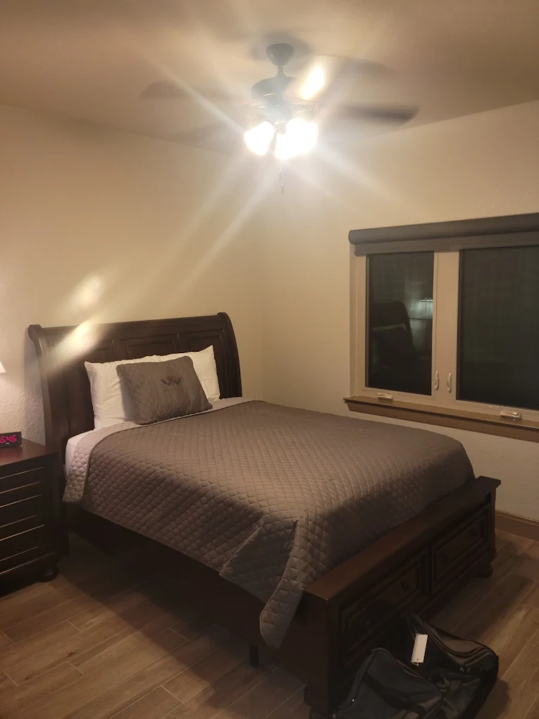 Single bed with brown linens in a warmly lit bedroom
