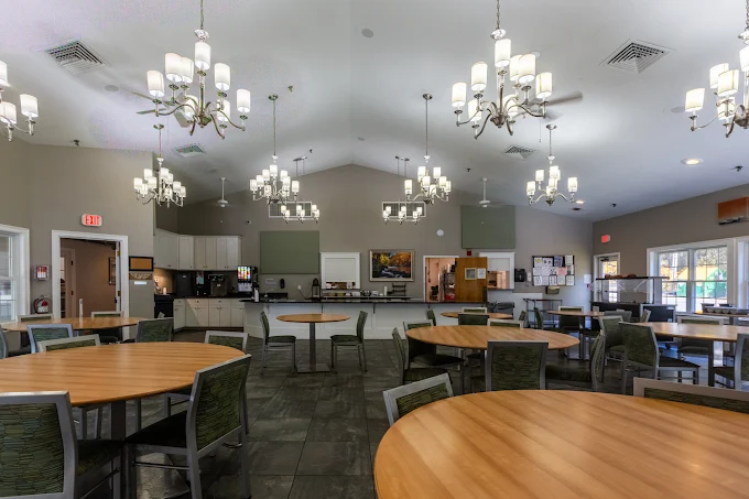 Spacious dining hall with round tables and chandeliers