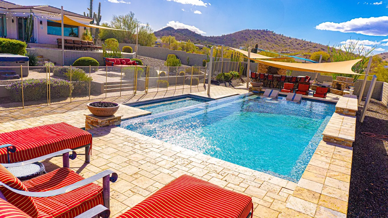 Resort-style pool with loungers and desert mountain views