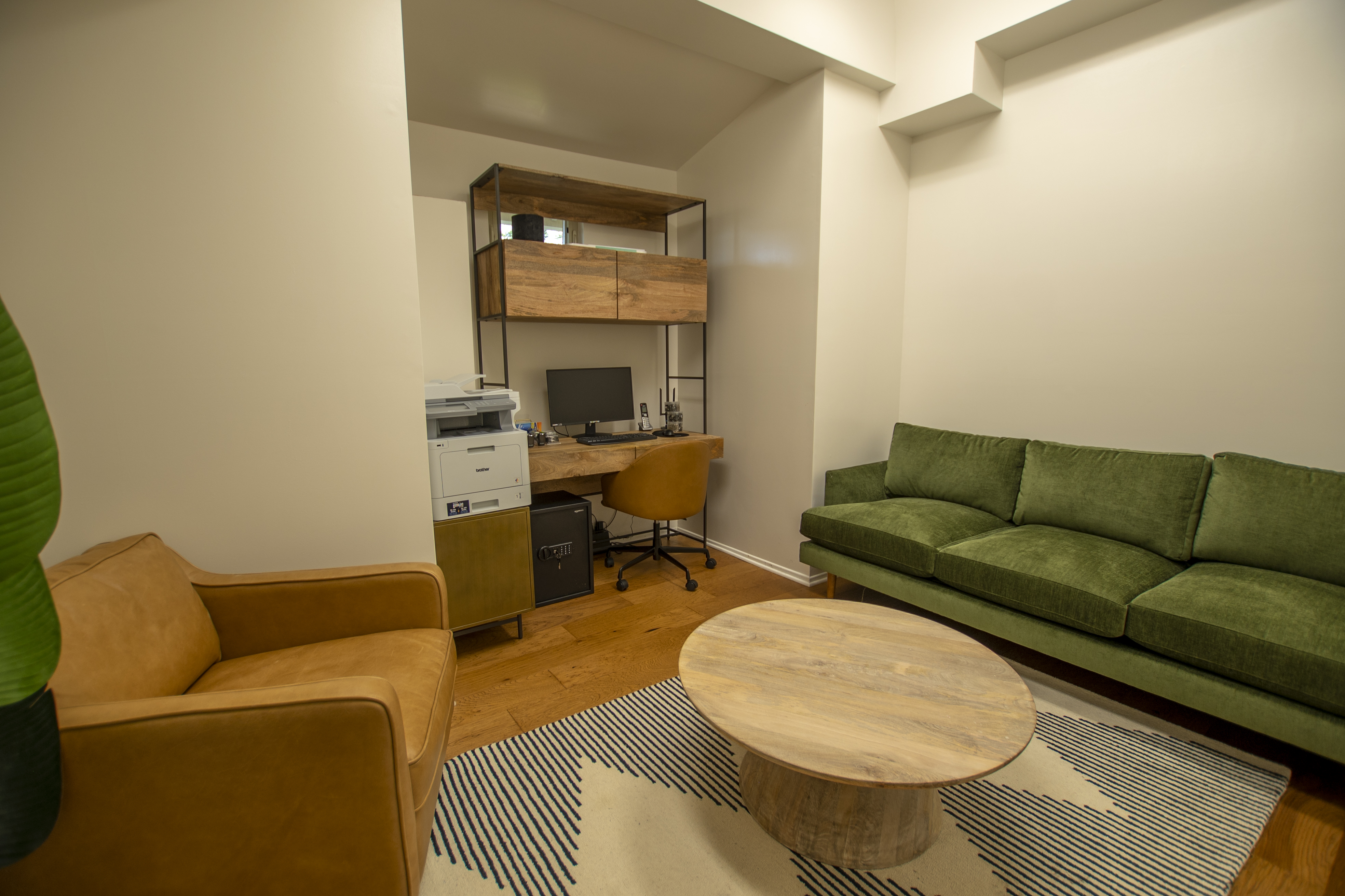 Office with green sofa, desk, and printer