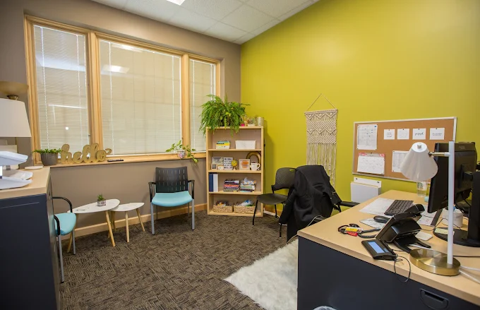 Cozy counseling office with desk, chairs, and shelves