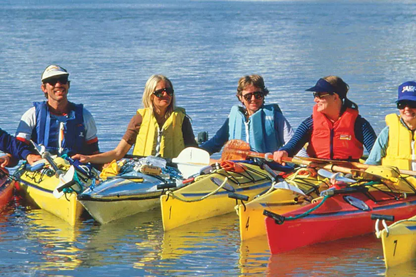 Group kayaking together on calm water