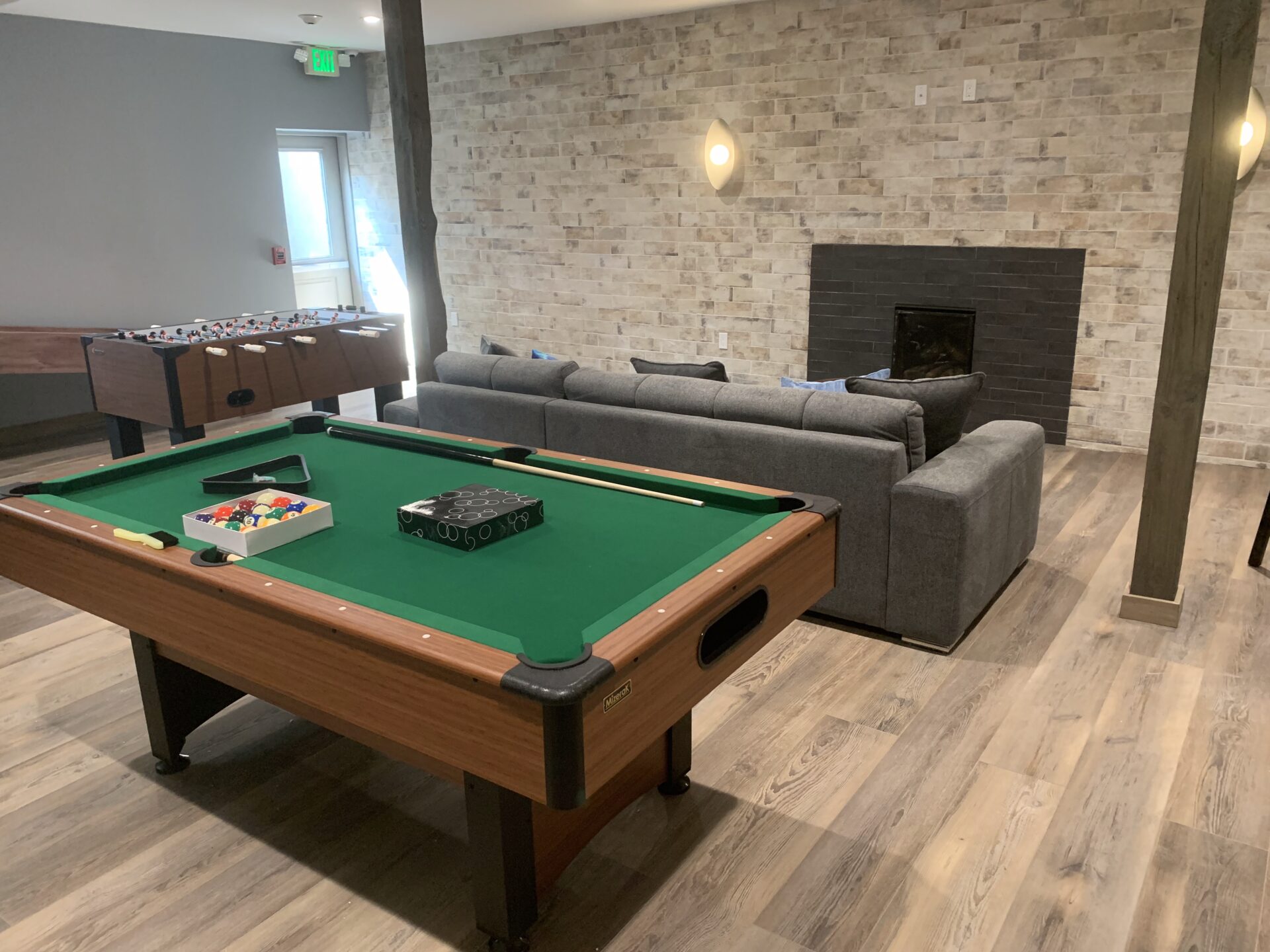 Recreational room with pool table, fireplace and foosball table.