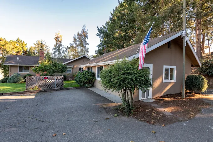 Rehab facility exterior with U.S. flag and greenery