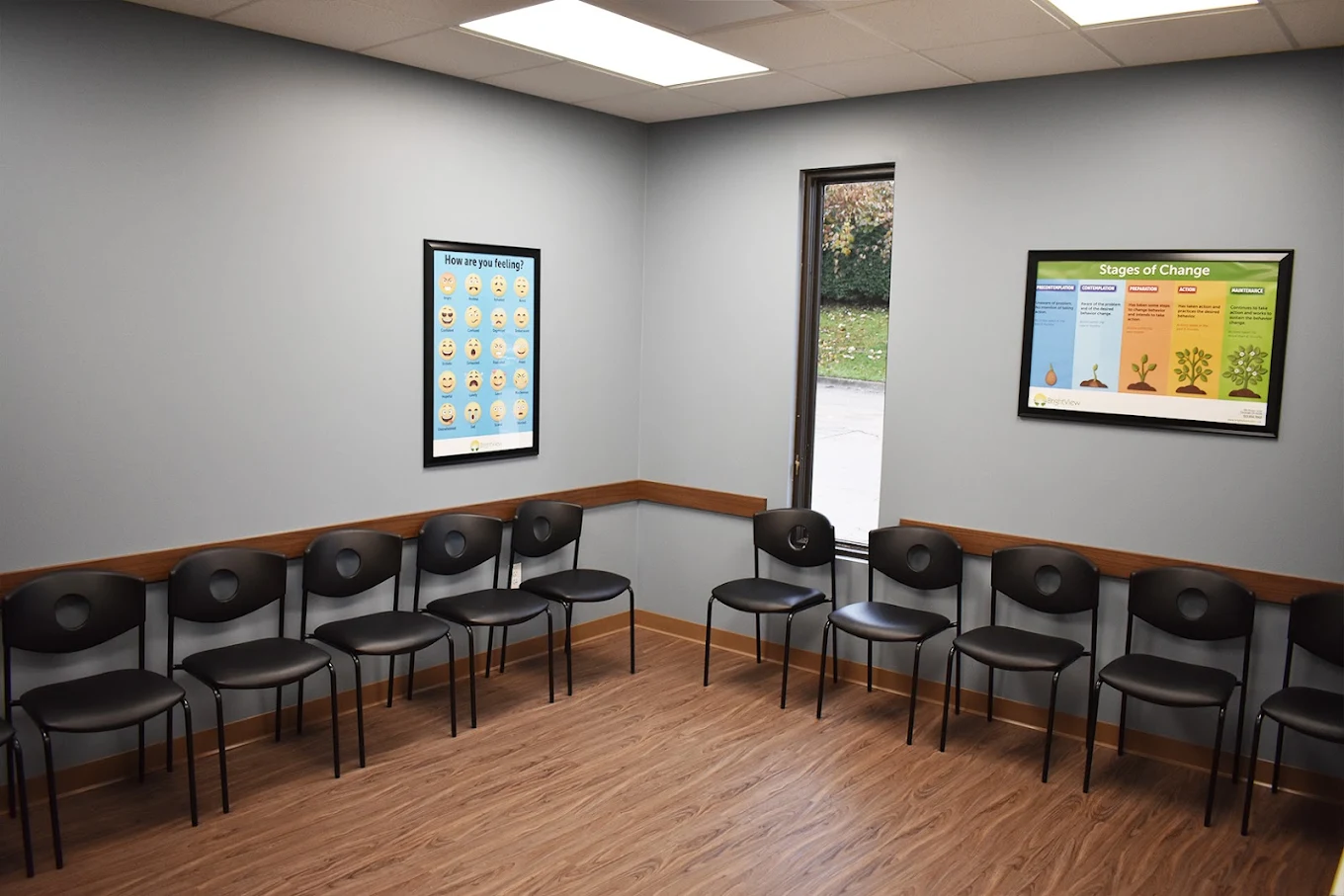 BrightView Akron group room with chairs arranged along the walls, recovery education posters, and wood-look flooring