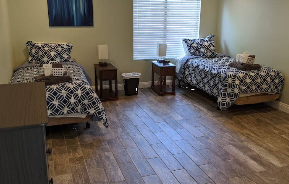 Two twin beds with geometric bedding in shared rehab bedroom