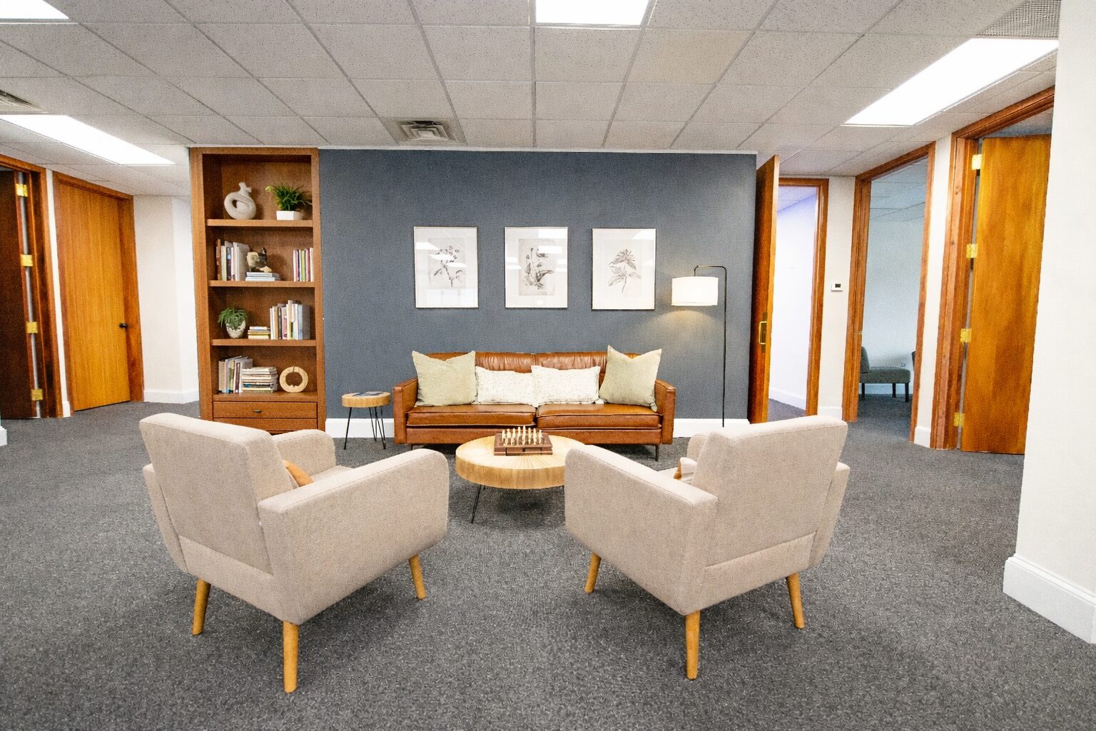 Lounge seating with sofa, chairs, and bookshelf decor