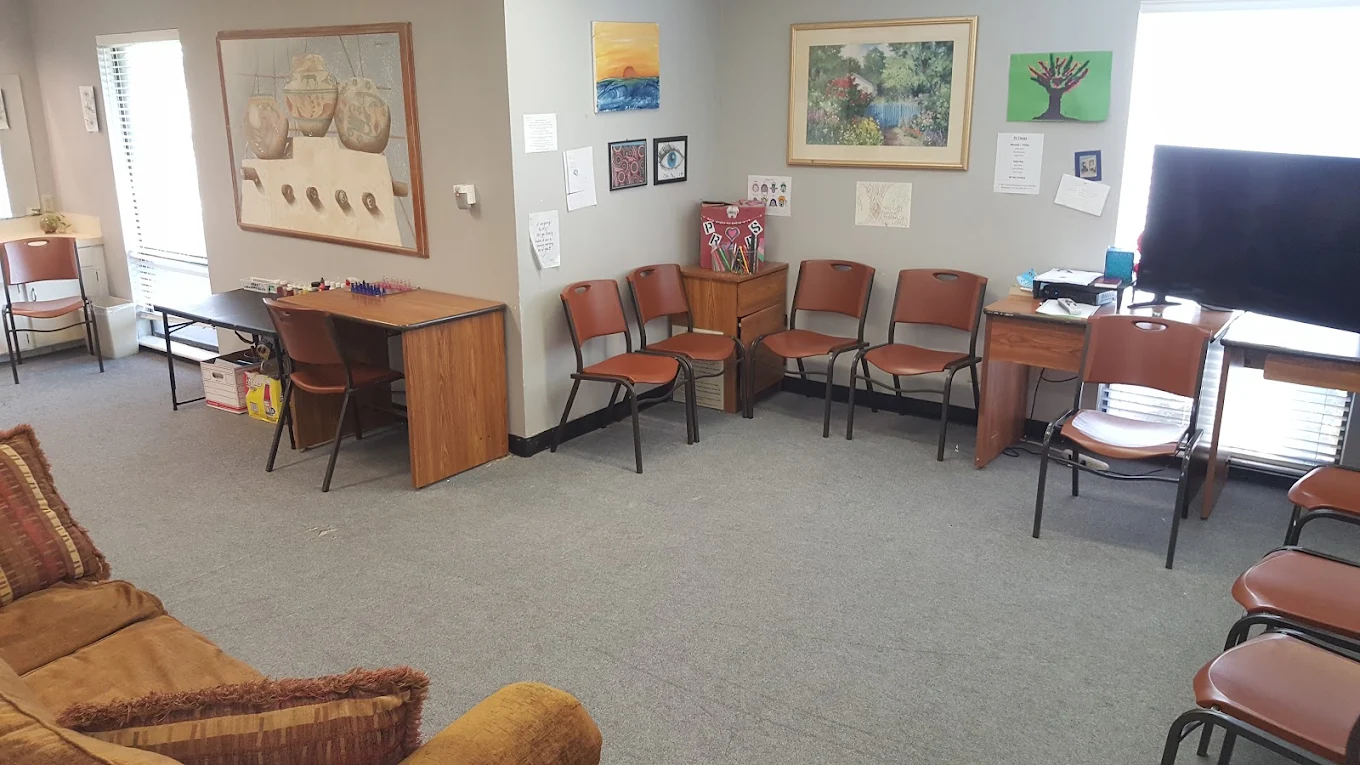 Room with seating, desks, and artwork on the walls.