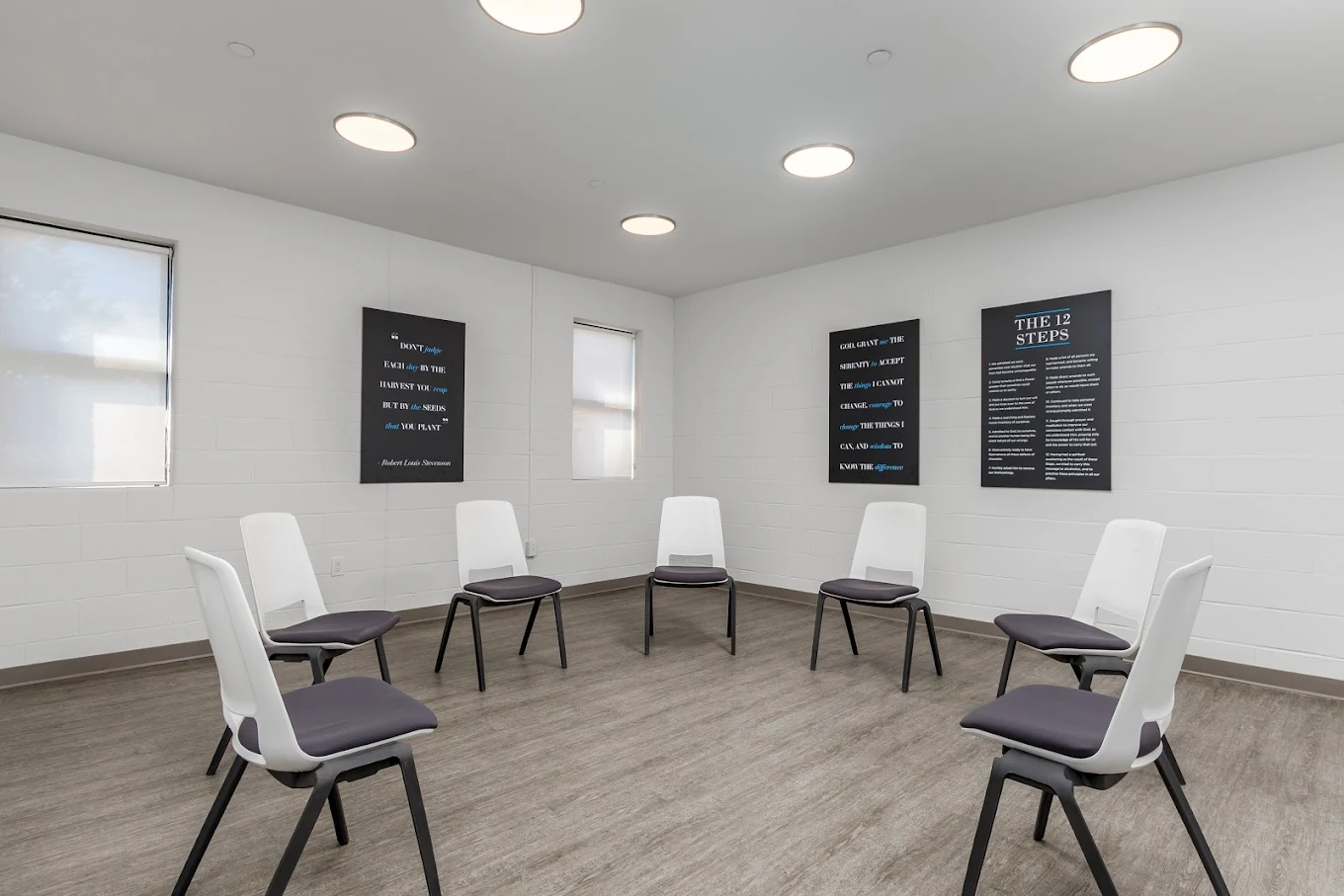 Circle of white chairs in bright therapy room