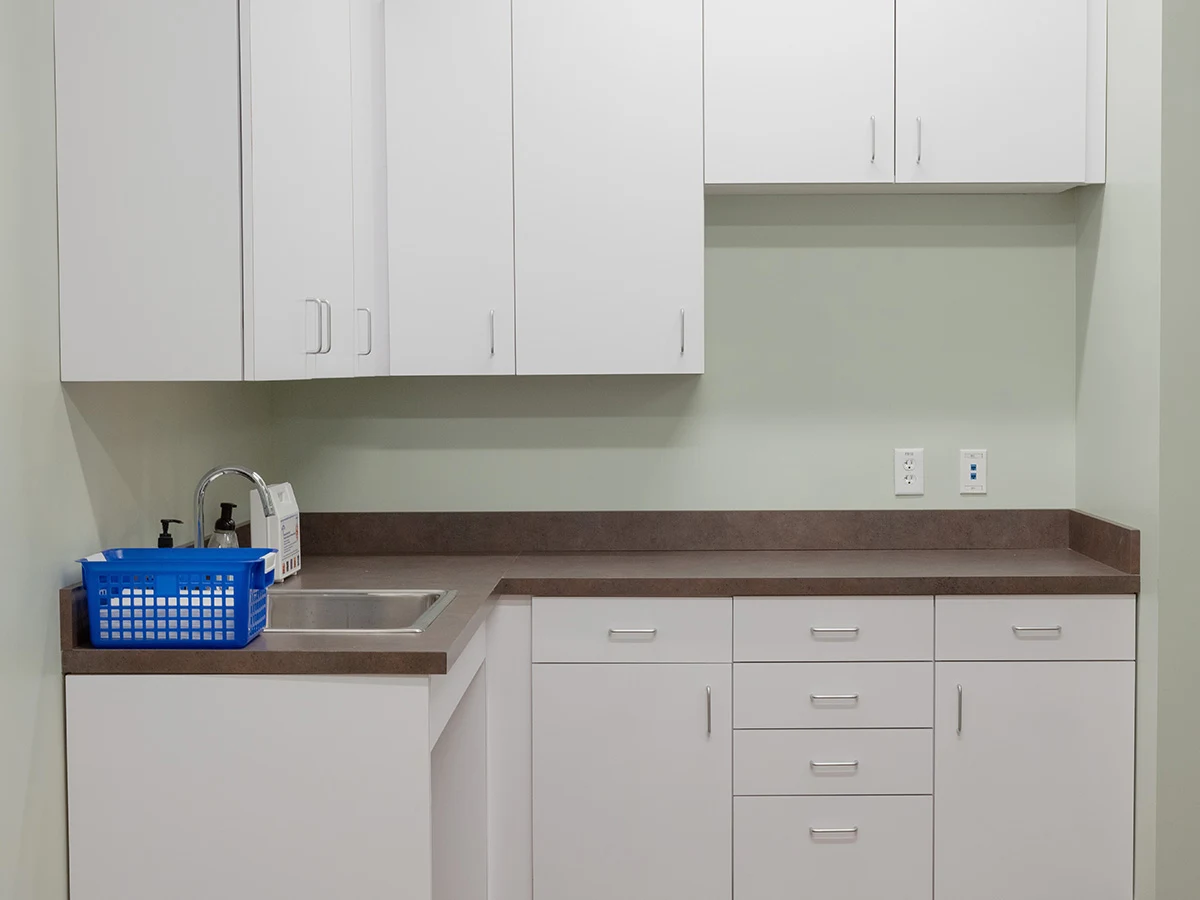 Counter with sink, cabinets, and medical supplies