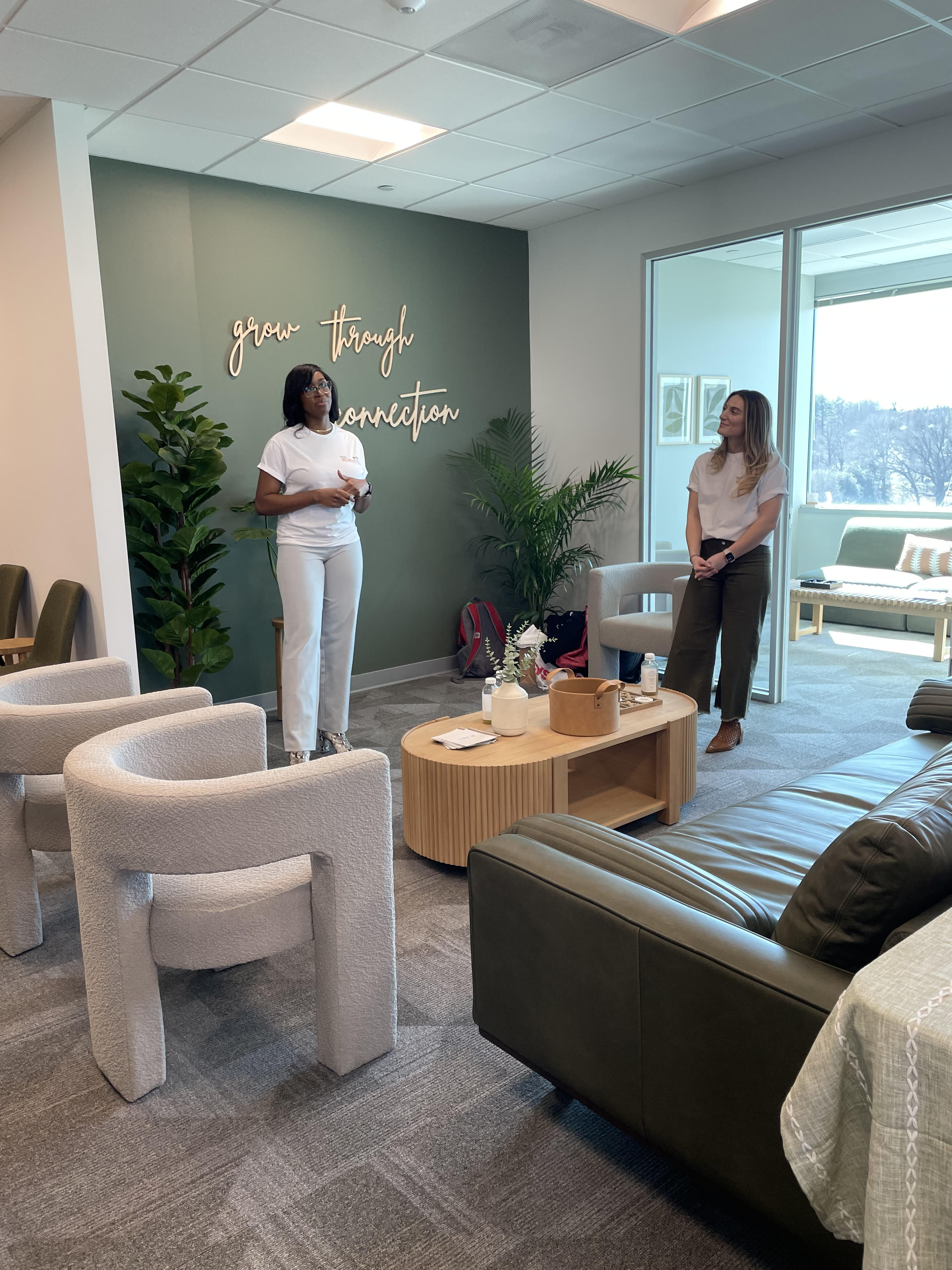 Two staff members standing in a welcoming space.