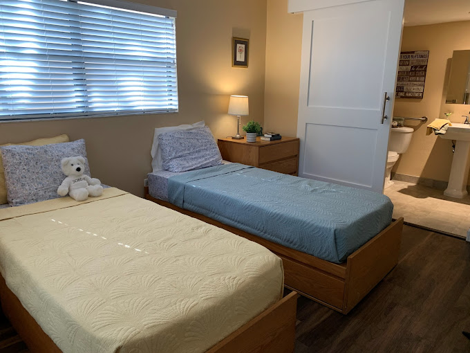 Two twin beds with a teddy bear and nightstand