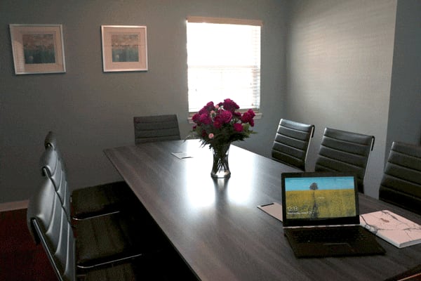 Table with leather chairs and vase of flowers