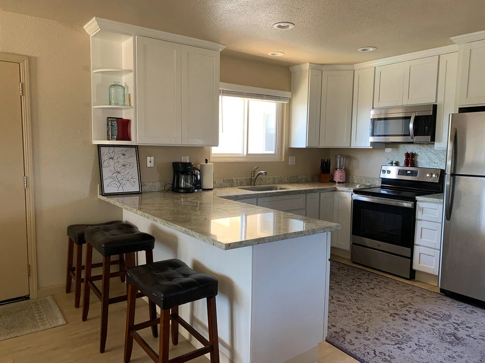 Modern shared kitchen with island, stainless appliances, and seating