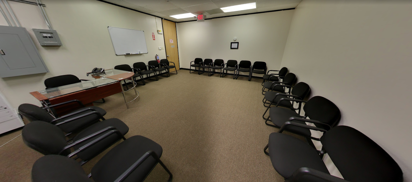 Large meeting room with chairs arranged along walls