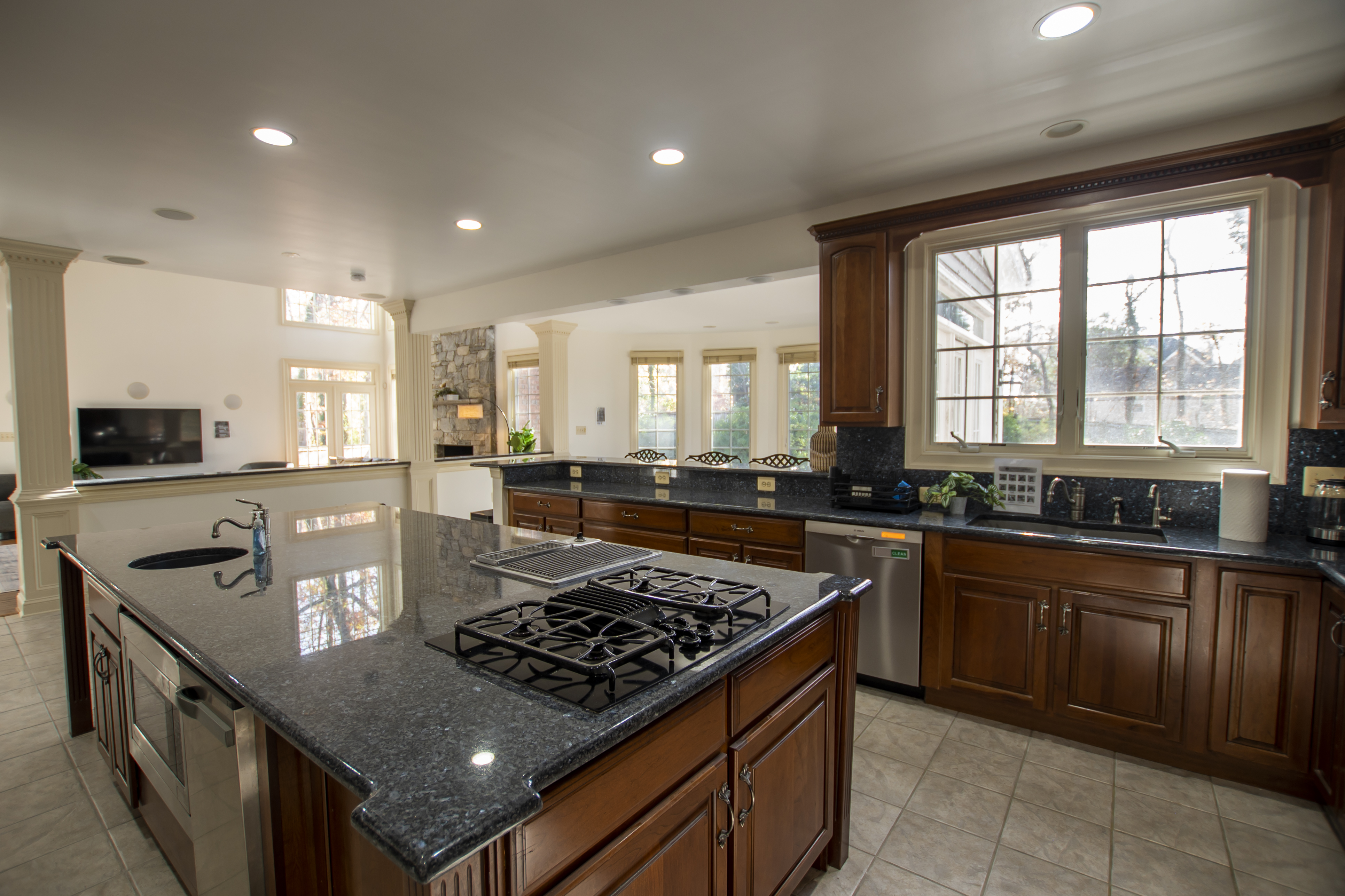 Spacious kitchen with granite island and wood cabinets.