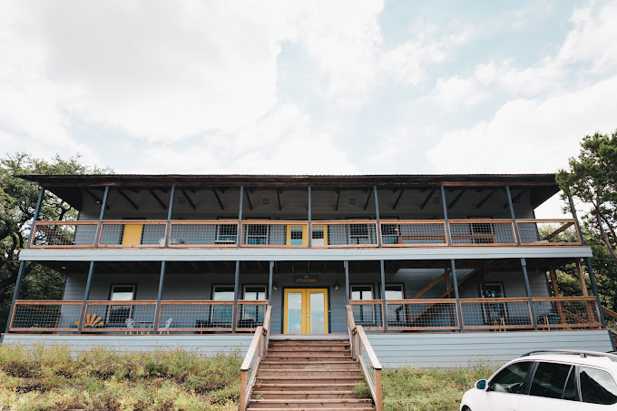 Two-story facility building with wooden staircase and porch