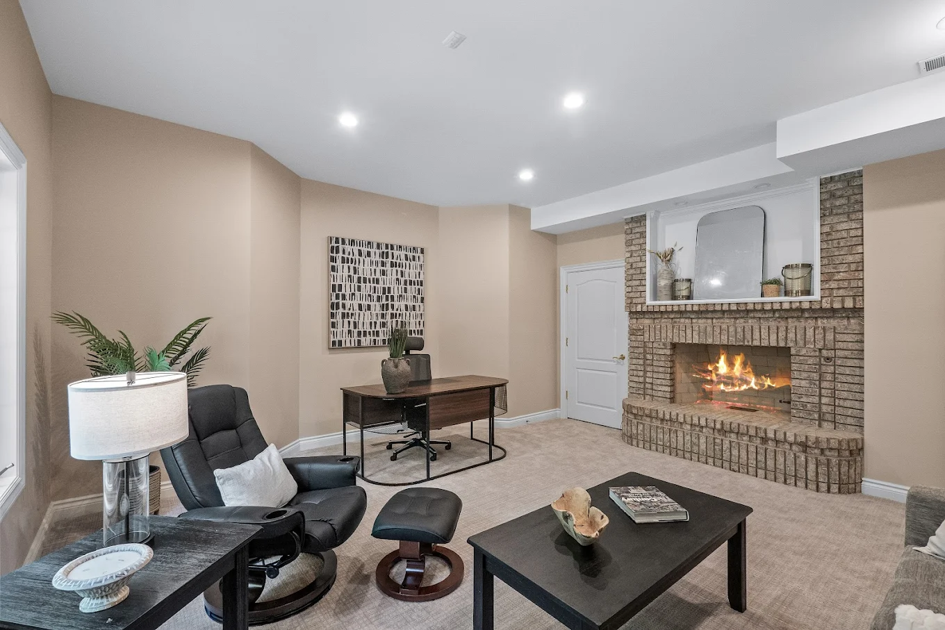 Therapy space with desk, recliner, and brick fireplace