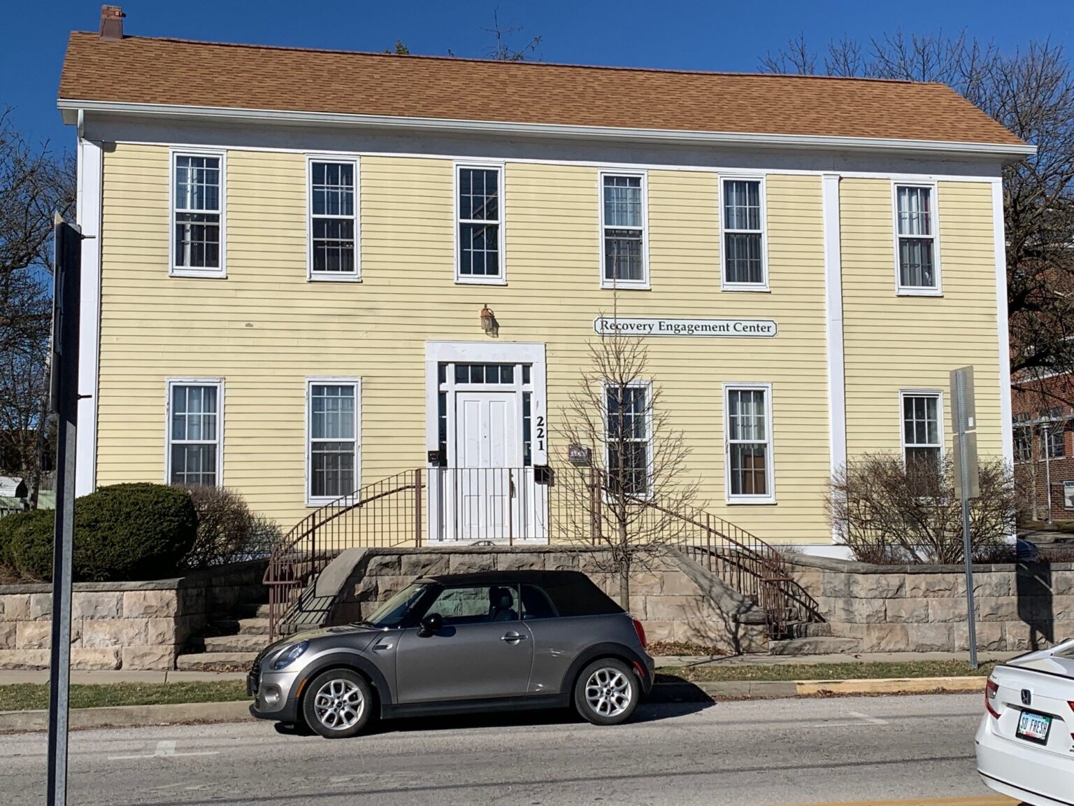 Yellow two-story building labeled "Recovery Engagement Center"