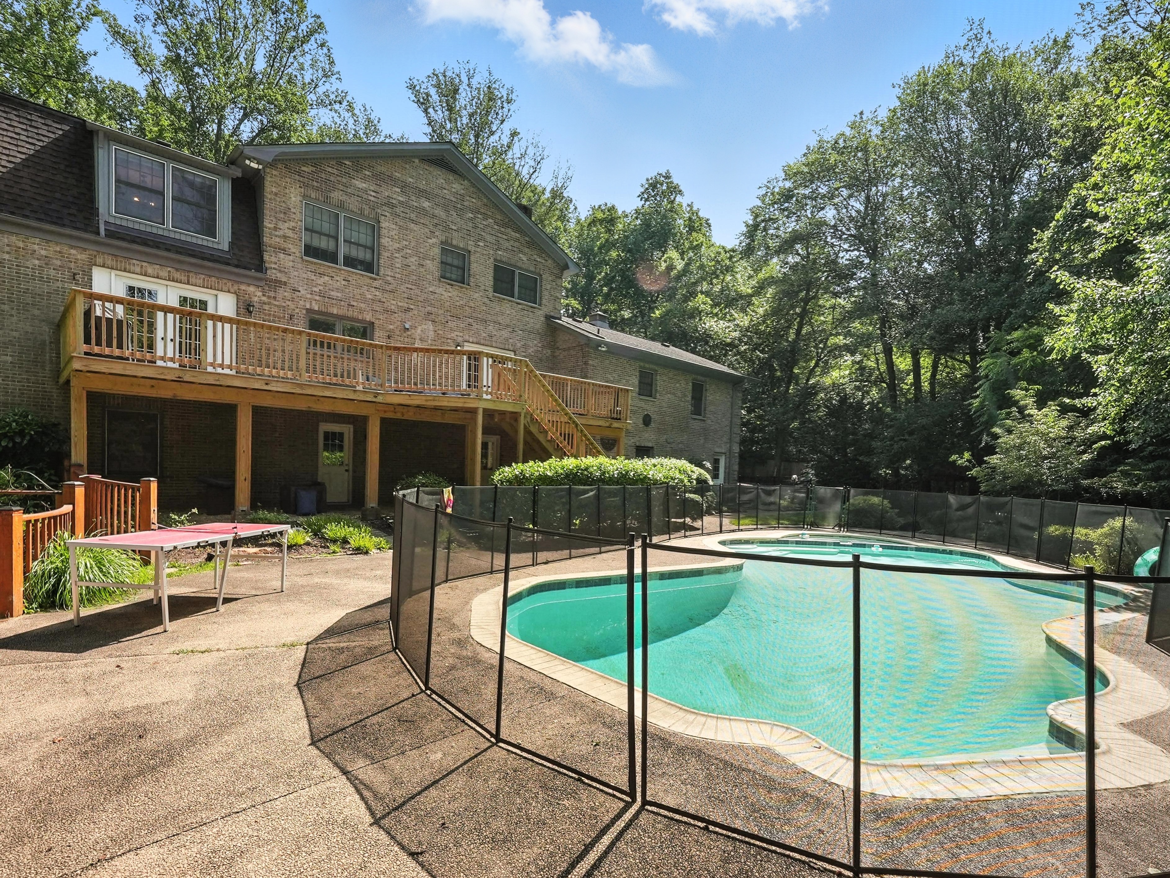 Outdoor pool with safety fence and deck at treatment facility.