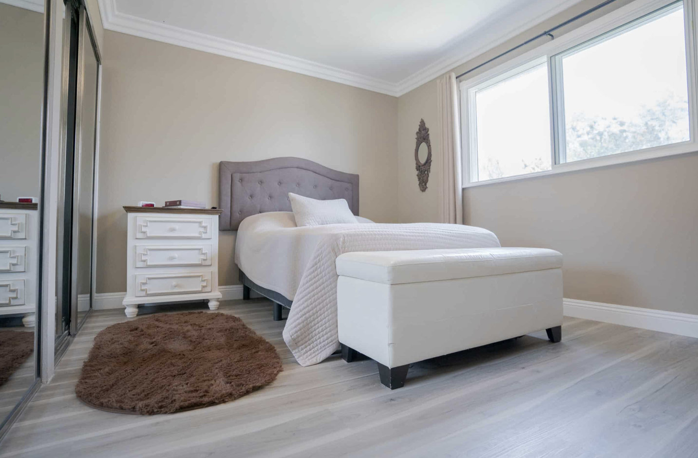 Private bedroom with a single bed, dresser, and mirrors.
