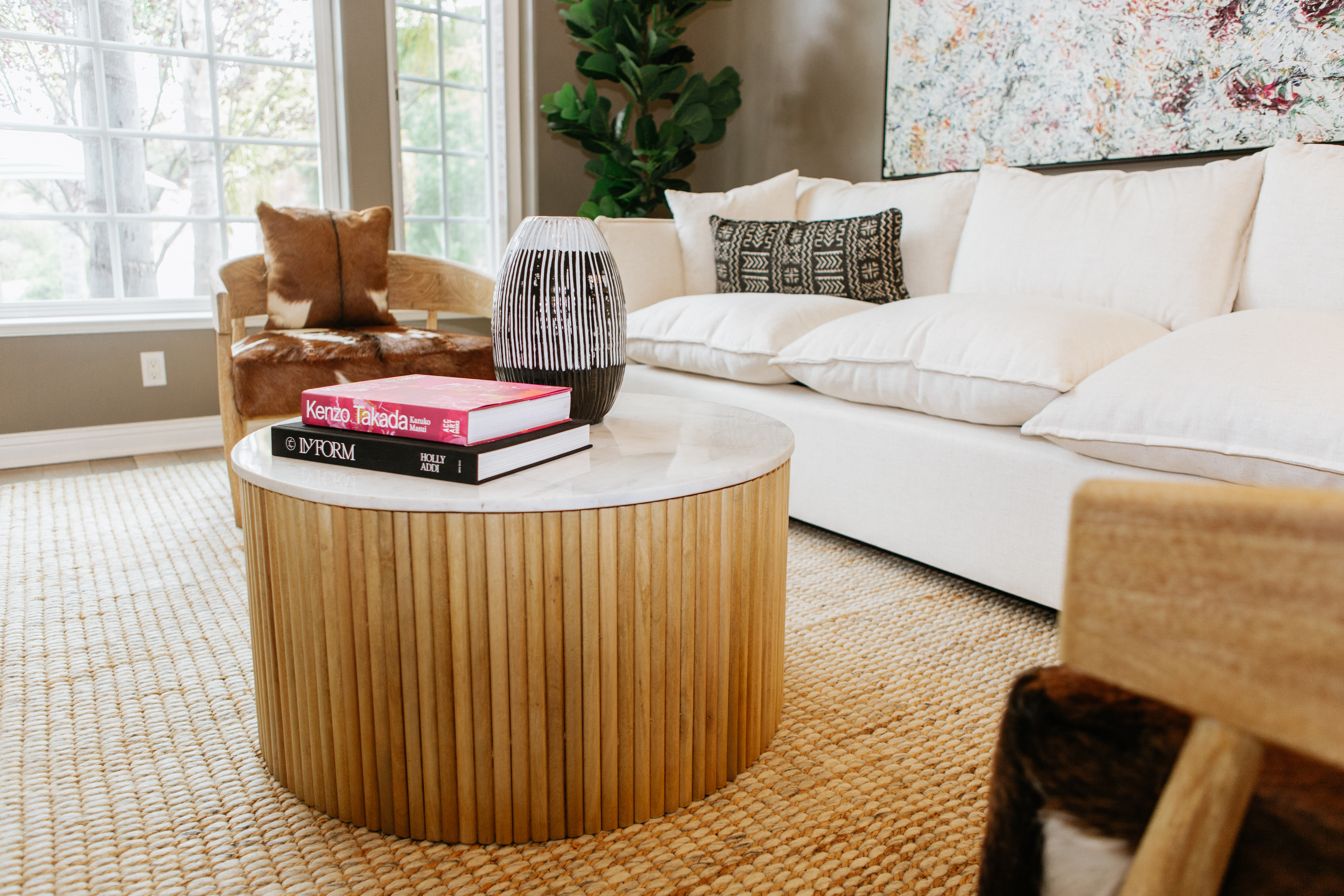 Coffee table with books and vase in front of white sofa