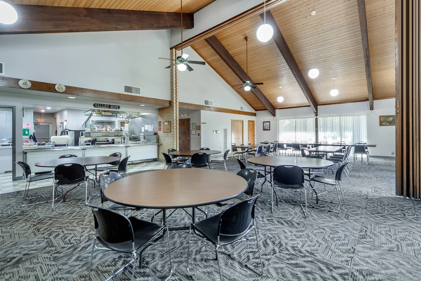 Communal dining hall with tables and on-site meal service