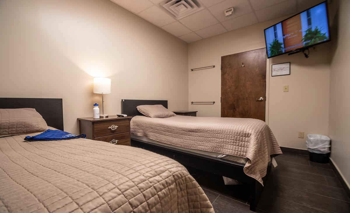 Two twin beds with TV and nightstand in shared room