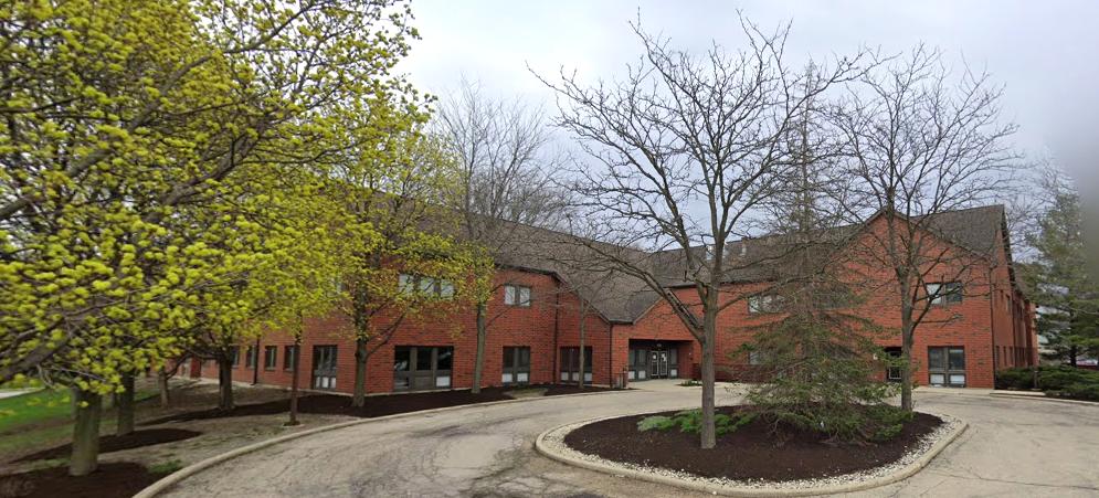 Rehab facility exterior with trees along driveway