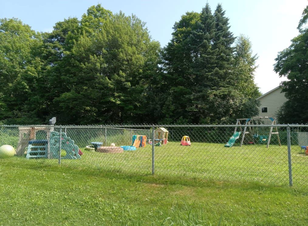 Fenced playground with swings and play sets